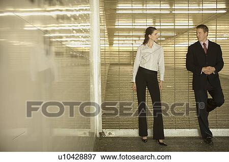A Pair of Office Workers Leaning Against a Shutter and Talking, Front View, Full Length View Large Photo Image Stock Photo - A Pair of Office Workers Leaning Against a Shutter and Talking, Front View, Full Length. Fotosearch