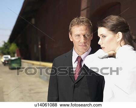 Stock Photo - A Pair of Office Workers on a Sidewalk, Differential Focus, Waist Up. Fotosearch