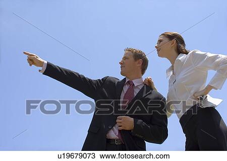 A Pair of Office Workers Pointing and Looking, Low Angle View, Waist Up View Large Photo Image Stock Image - A Pair of Office Workers Pointing and Looking, Low Angle View, Waist Up. Fotosearch