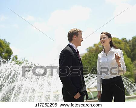 Stock Photography - A Pair of Talking Office Workers by the Fountain. Fotosearch