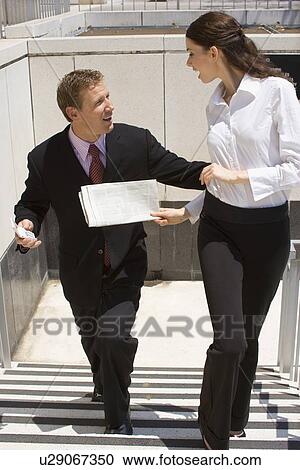 Stock Image - A Pair of Talking Office Workers, Front View, Full Length. Fotosearch