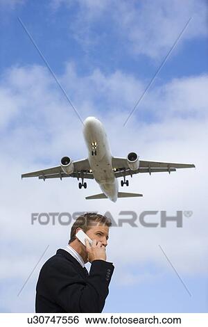 A Telephone Calling Businessman with a Airplane in the Background, Low Angle View, Waist Up View Large Photo Image Stock Photograph - A Telephone Calling Businessman with a Airplane in the Background, Low Angle View, Waist Up. Fotosearch