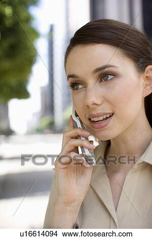 Picture - A Young Adult Businesswoman Talking on the Cellular Phone, Head and Shoulders, Differential Focus. Fotosearch