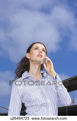 A Young Adult Businesswoman Talking on a Cellular Phone, Low Angle View, Waist Up View Large Photo Image Stock Image - A Young Adult Businesswoman Talking on a Cellular Phone, Low Angle View, Waist Up. Fotosearch