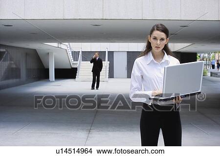 A Young Adult Businesswoman Using a Notebook Computer, Front View, Three Quarter Length View Large Photo Image Picture - A Young Adult Businesswoman Using a Notebook Computer, Front View, Three Quarter Length. Fotosearch