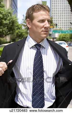 Portrait of a Mid Adult Businessman Putting on a Jacket, Front View, Waist Up View Large Photo Image Stock Image - Portrait of a Mid Adult Businessman Putting on a Jacket, Front View, Waist Up. Fotosearch