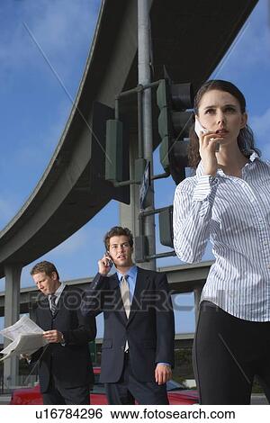 Stock Photograph - Three Office Workers by the Elevated Road, Low Angle View, Three Quarter Length, Front View. Fotosearch