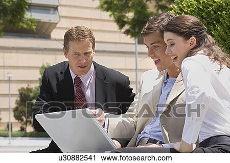Three Office Workers Looking at a Computer Screen and Smiling, Waist Up View Large Photo Image Stock Image - Three Office Workers Looking at a Computer Screen and Smiling, Waist Up. Fotosearch