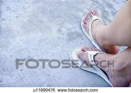 Stock Photograph - Woman's feet wearing beach sandals, High Angle View, Copy Space. Fotosearch