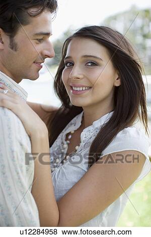 Young adult couple holding each other, Side View, Differential Focus View Large Photo Image Stock Photo - Young adult couple holding each other, Side View, Differential Focus. Fotosearch