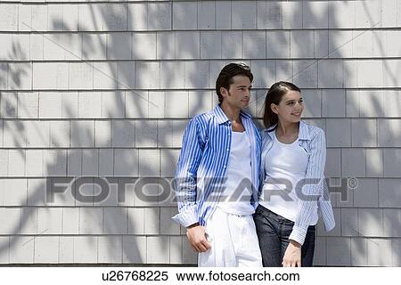Young adult couple leaning together on wall, Front View, Copy Space View Large Photo Image Stock Photography - Young adult couple leaning together on wall, Front View, Copy Space. Fotosearch