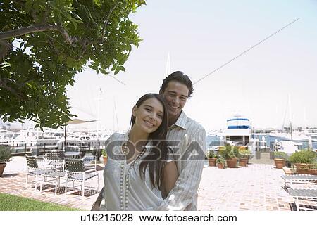 Stock Photo - Young adult couple smiling at camera, Front View. Fotosearch