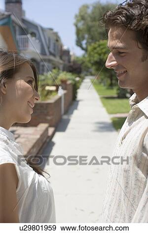 Young adult couple smiling at each other, Side View, Differential Focus View Large Photo Image Stock Photo - Young adult couple smiling at each other, Side View, Differential Focus. Fotosearch