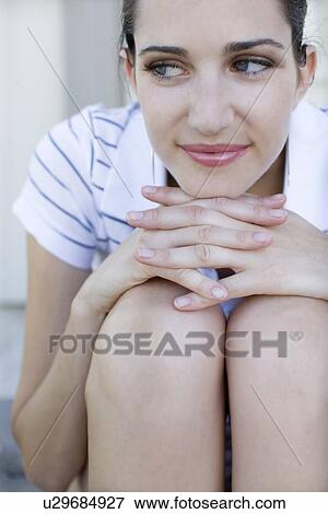 Young adult woman sitting with arms around knees, Front View, Differential Focus View Large Photo Image Stock Photo - Young adult woman sitting with arms around knees, Front View, Differential Focus. Fotosearch