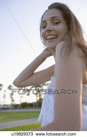Young adult woman smiling at camera, Side View, Low Angle View, Differential Focus View Large Photo Image Stock Image - Young adult woman smiling at camera, Side View, Low Angle View, Differential Focus. Fotosearch