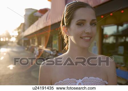 Young adult woman smiling at camera, Front View, Lens Flare, Differential Focus View Large Photo Image Stock Photography - Young adult woman smiling at camera, Front View, Lens Flare, Differential Focus. Fotosearch