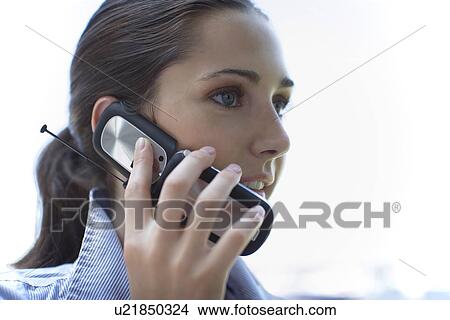 Picture - Young adult woman talking on mobile phone, Side View, Low Angle View, Differential Focus. Fotosearch