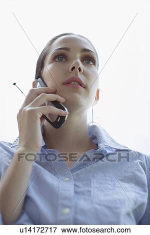Young adult woman talking on mobile phone, Low Angle View, Differential Focus View Large Photo Image Stock Photo - Young adult woman talking on mobile phone, Low Angle View, Differential Focus. Fotosearch