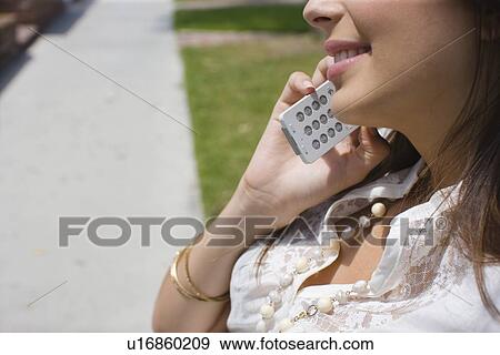 Young adult woman talking on mobile phone, Side View, Differential Focus View Large Photo Image Stock Photo - Young adult woman talking on mobile phone, Side View, Differential Focus. Fotosearch