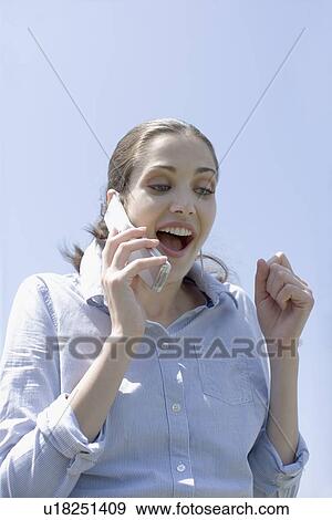 Young adult woman talking on mobile phone, Low Angle View View Large Photo Image Stock Photo - Young adult woman talking on mobile phone, Low Angle View. Fotosearch