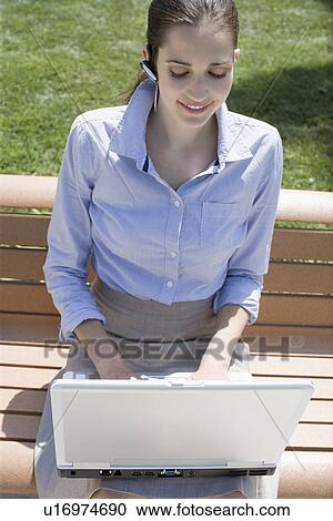 Young adult woman using a laptop computer outdoors, High Angle View View Large Photo Image Stock Image - Young adult woman using a laptop computer outdoors, High Angle View. Fotosearch