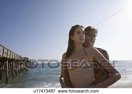 Young adult couple looking away on beach, Front View, Copy Space View Large Photo Image Stock Photo - Young adult couple looking away on beach, Front View, Copy Space. Fotosearch