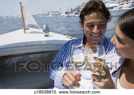 Stock Photography - Young adult couple on a cruiser toasting with wine, Front View, Side View. Fotosearch
