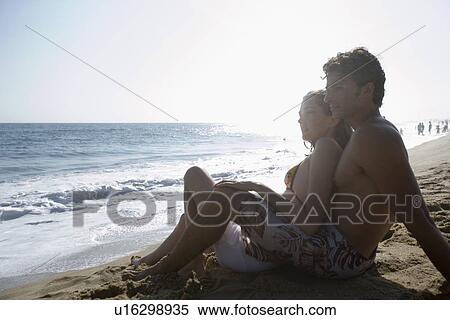 Young adult couple sitting together on beach, Side View, Copy Space View Large Photo Image Stock Photography - Young adult couple sitting together on beach, Side View, Copy Space. Fotosearch