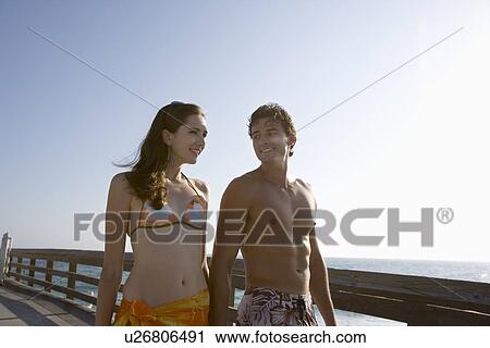 Young adult couple walking on pier, Side View View Large Photo Image Stock Image - Young adult couple walking on pier, Side View . Fotosearch