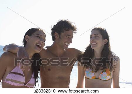 Stock Image - Young adult man holding women's shoulders, Front View, Differential Focus. Fotosearch