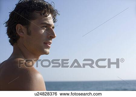Young adult man looking away on beach, Side View, Differential Focus, Copy Space View Large Photo Image Stock Photograph - Young adult man looking away on beach, Side View, Differential Focus, Copy Space . Fotosearch
