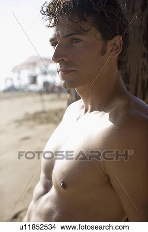 Young adult man on beach, Side View, Differential Focus View Large Photo Image Picture - Young adult man on beach, Side View, Differential Focus. Fotosearch