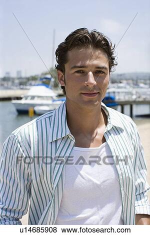 Young adult man smiling at camera, Front View, Differential Focus View Large Photo Image Stock Photo - Young adult man smiling at camera, Front View, Differential Focus. Fotosearch