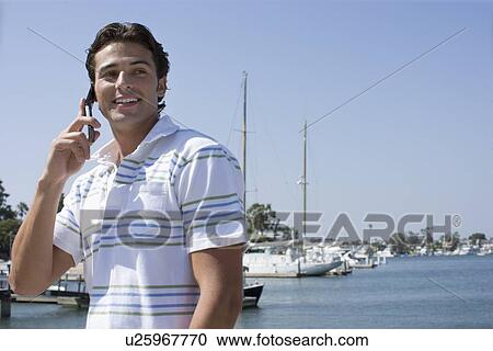 Young adult man talking on mobile phone, Front View, Side View, Copy Space View Large Photo Image Stock Image - Young adult man talking on mobile phone, Front View, Side View, Copy Space . Fotosearch