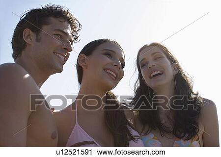 Stock Image - Young adult people in swimming wears smiling, Low Angle View. Fotosearch