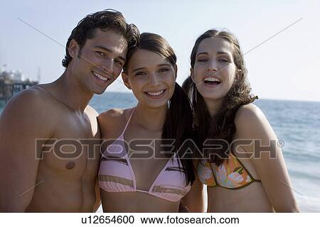 Stock Image - Young adult people on beach smiling, Front View, Differential Focus. Fotosearch