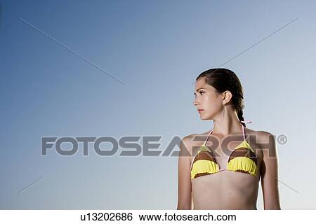 Young adult woman in bikini looking away, Low Angle View, Copy Space View Large Photo Image Stock Photograph - Young adult woman in bikini looking away, Low Angle View, Copy Space. Fotosearch