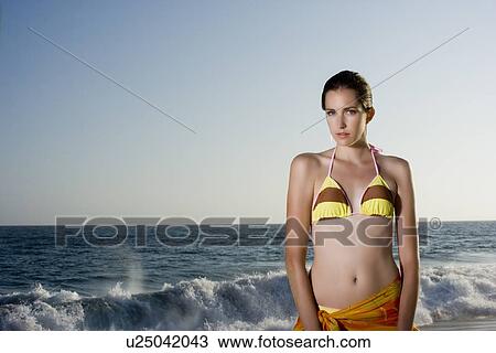 Young adult woman in bikini standing on beach, Front View, Copy Space View Large Photo Image Stock Image - Young adult woman in bikini standing on beach, Front View, Copy Space . Fotosearch