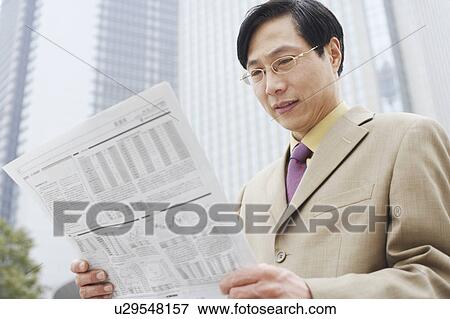Close-up of a businessman reading a newspaper View Large Photo Image Stock Photo - Close-up of a businessman reading a newspaper. Fotosearch