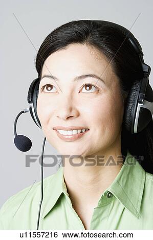 Close-up of a businesswoman smiling with a headset View Large Photo Image Stock Photograph - Close-up of a businesswoman smiling with a headset. Fotosearch