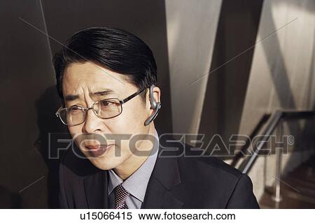 High angle view of a businessman wearing a hands free device View Large Photo Image Stock Photography - High angle view of a businessman wearing a hands free device. Fotosearch