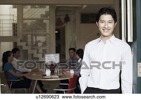Portrait of a businessman leaning against a door and smiling View Large Photo Image Stock Image - Portrait of a businessman leaning against a door and smiling. Fotosearch