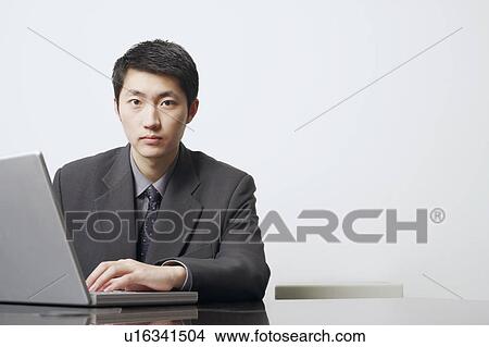 Portrait of a businessman using a laptop View Large Photo Image Picture - Portrait of a businessman using a laptop. Fotosearch