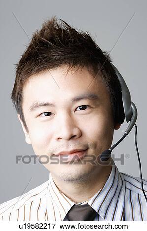 Portrait of a businessman using a headset View Large Photo Image Stock Photo - Portrait of a businessman using a headset. Fotosearch