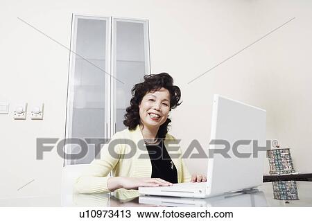 Portrait of a businesswoman using a laptop smiling View Large Photo Image Stock Image - Portrait of a businesswoman using a laptop smiling. Fotosearch