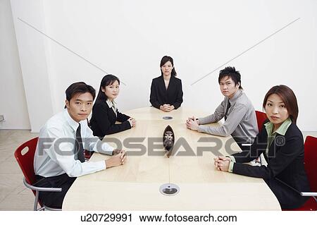 Stock Image - Portrait of business executives sitting in a board room. Fotosearch