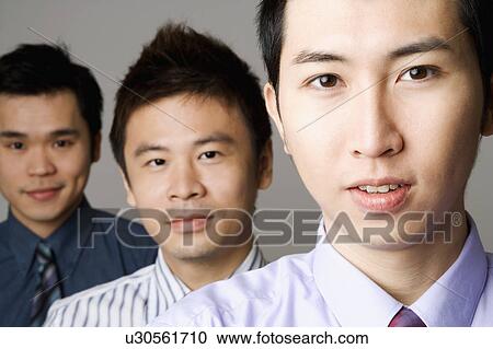 Stock Image - Portrait of three businessmen in a row. Fotosearch