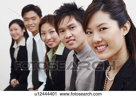 Stock Image - Portrait of three businesswomen with two businessmen smiling. Fotosearch