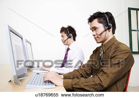 Two customer service representatives working on a computer View Large Photo Image Stock Photography - Two customer service representatives working on a computer. Fotosearch