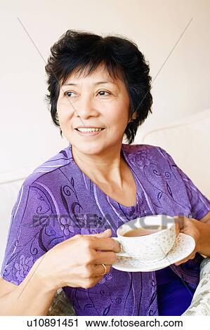 Close-up of a mature woman holding a cup of tea View Large Photo Image Stock Image - Close-up of a mature woman holding a cup of tea. Fotosearch